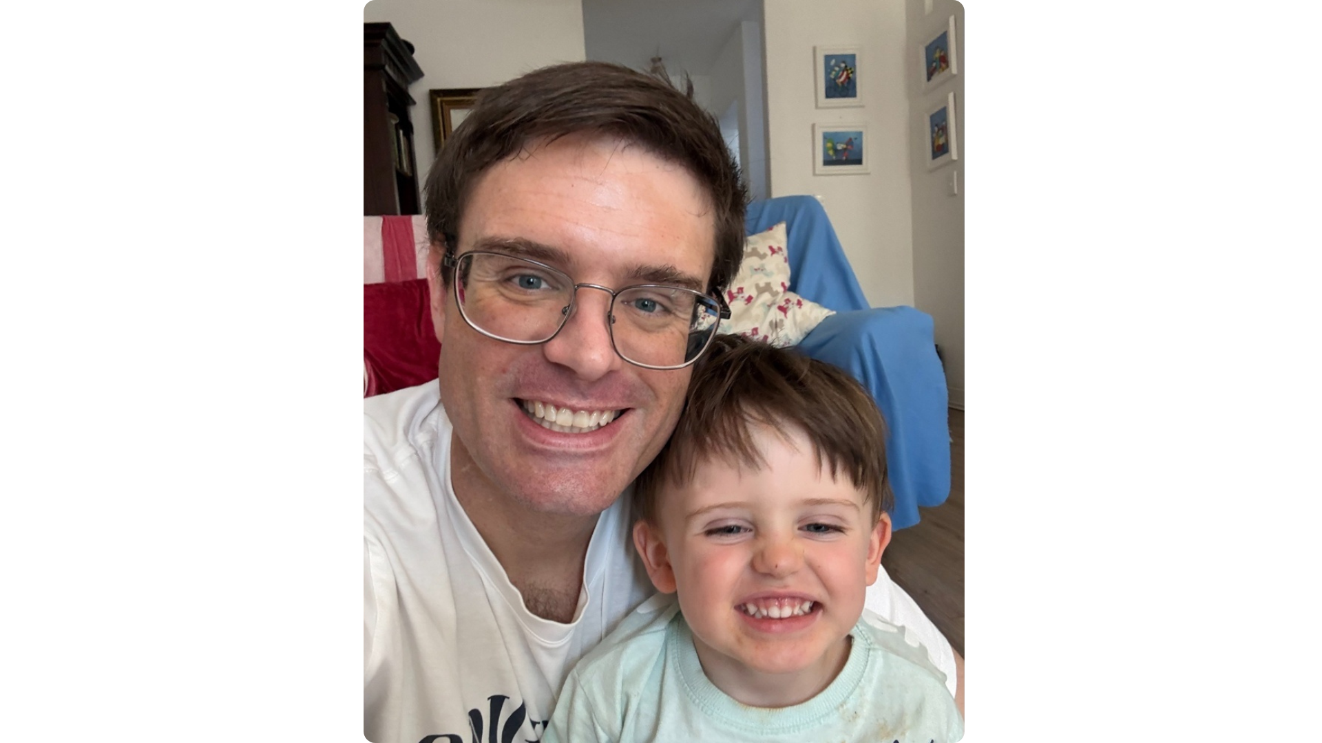 Warrick and his son smiling together at home